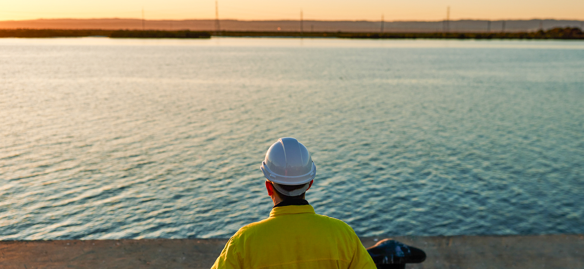 Shipbuilder at sunrise looking over the Port River at the Osborne Naval Shipyard