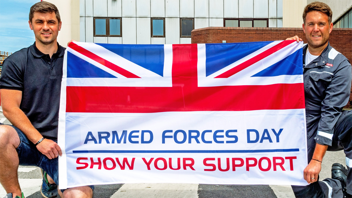 Two people holding Armed Forces Day flag