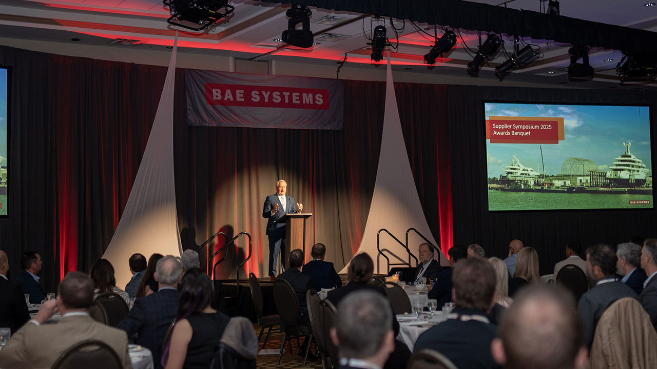 Matt Paxton stands on stage at the Ship Repair Supplier Symposium