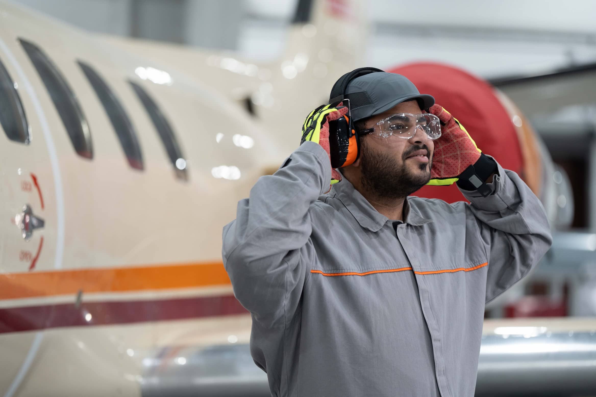Employee wearing ear protection in indoor hangar