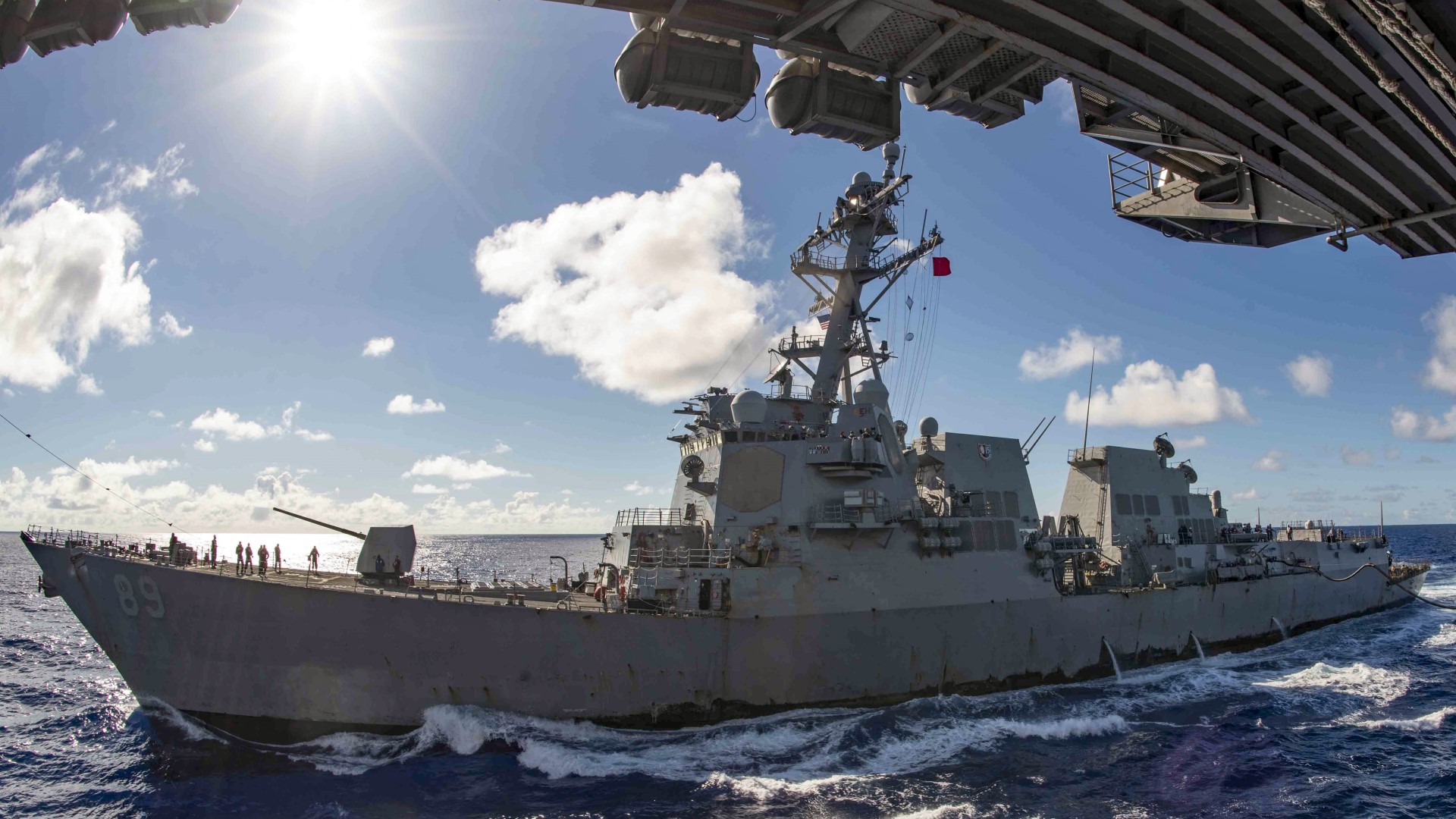 The guided missile destroyer USS Mustin conducts a replenishment with the aircraft carrier USS Ronald Reagan in the Philippine Sea. U.S. Navy image.