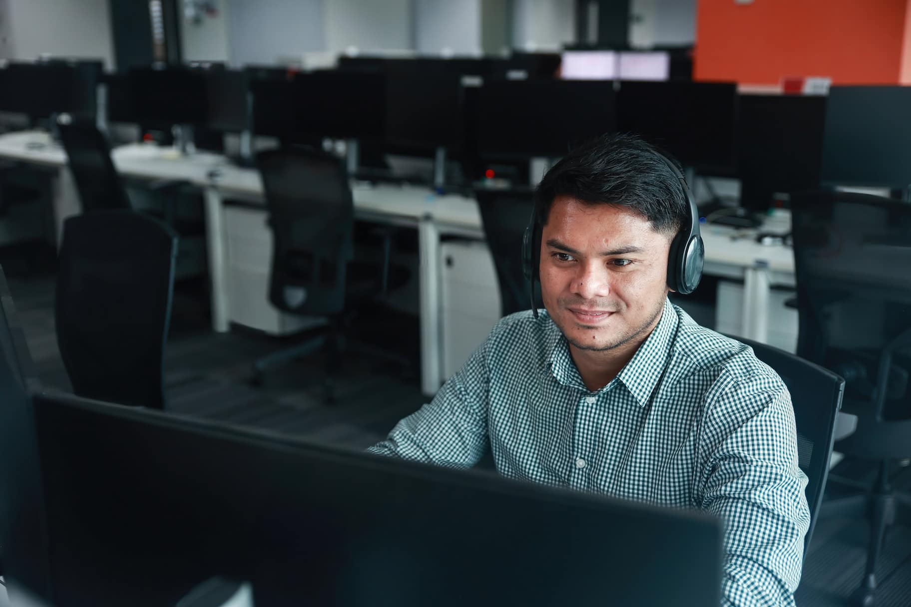 Employee in front of monitor in spacious office
