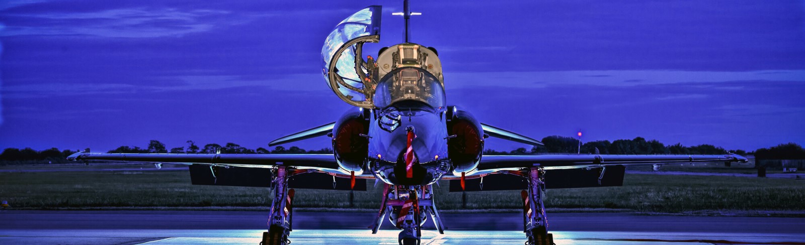 Hawk aircraft on runway at dusk