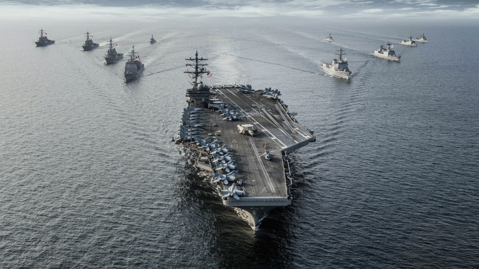 Aircraft carrier steams in formation with ships