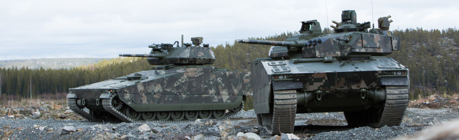 Two CV90 vehicles in gravel
