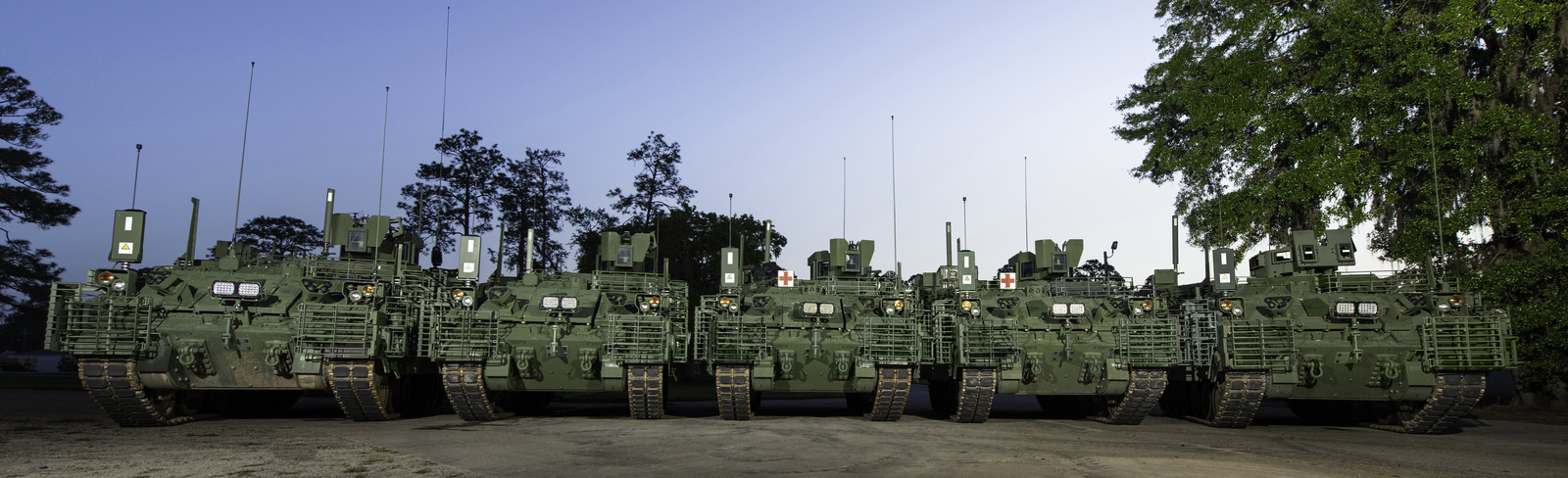 Several green army vehicles lined up
