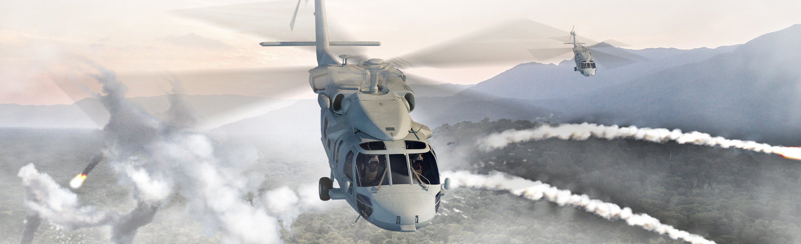 Rotary wing MH-60S Seahawk in flight with mountain range in distance and countermeasures being dispensed from platform.  