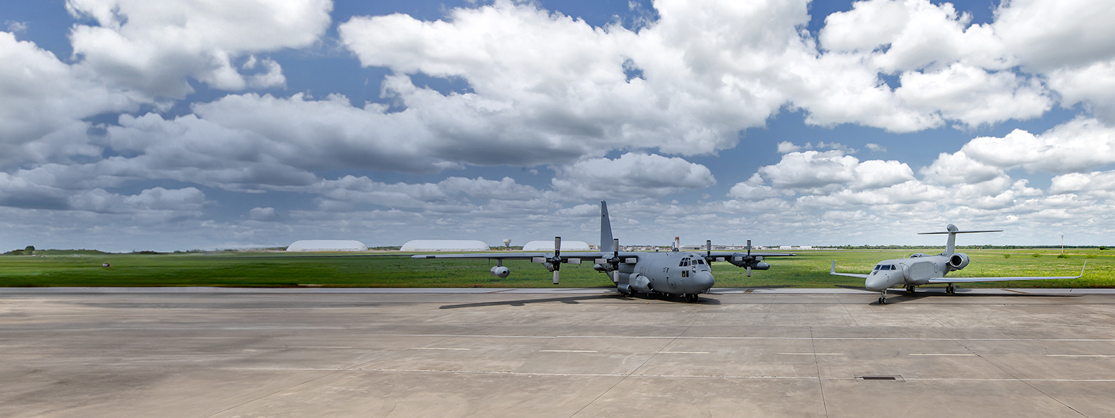 A EC-130H stands on the tarmac beside an EC-37B electromagnetic attack mission aircraft.